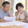 見積書を見比べて害獣駆除業者を選ぶ60代の夫婦