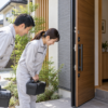 依頼を受けてすぐ駆けつけた駆除作業員が、玄関先で依頼者にあいさつする様子